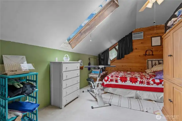 Bedroom #2 w/wood paneled accent wall, Vaulted Ceilings, Ceiling Fan and Skylight.