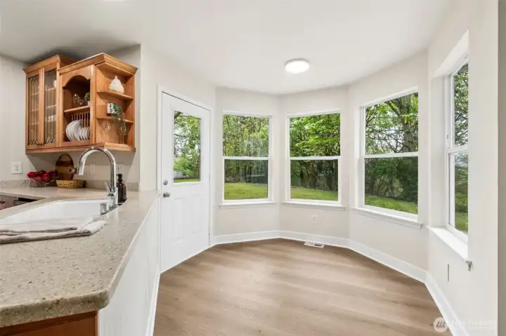 A sunny breakfast nook with Bay window overlooks the expansive backyard and your own forest, making every meal feel peaceful and connected to nature. It’s the perfect spot for morning coffee.