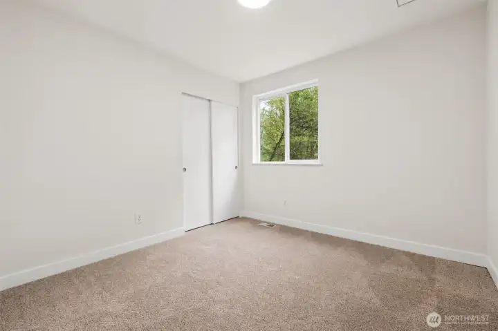 Bedroom #3 with fresh paint, soft carpet underfoot and your own gorgeous, forest views.