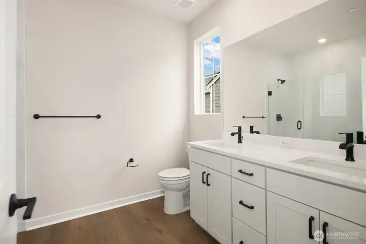 Primary bath with large, walk-in shower with bench. Similar home shown.