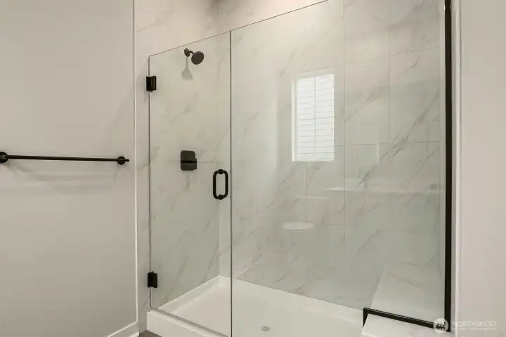Frameless walk-in shower with bench and floor-to-ceiling tile