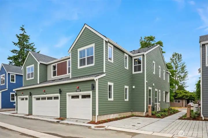 Garage and side of home with additional open parking next to home.