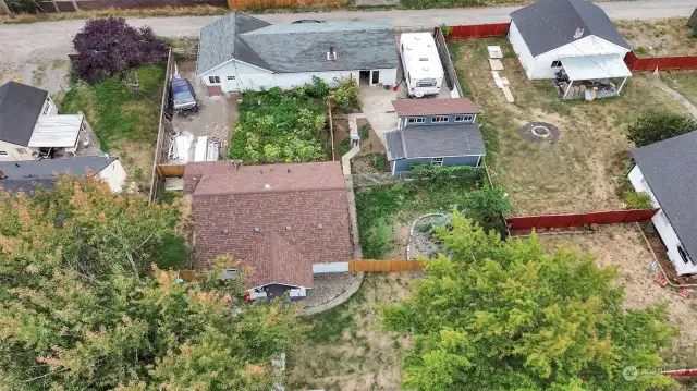 Fence to left of Long white garage and just right of RV parking pad in photo.