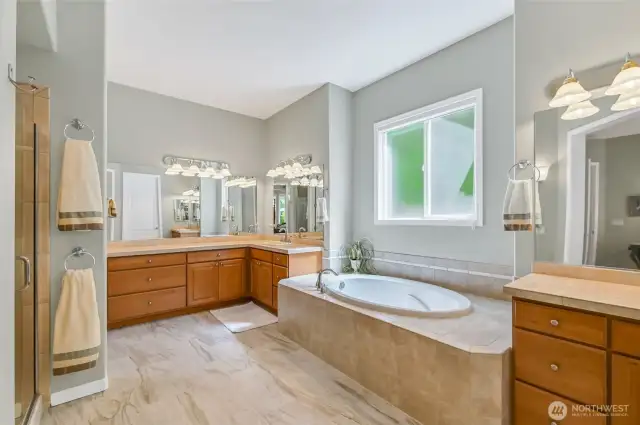 The primary bath has a heated floor, and the step-in shower has a new door. Two separate vanities with lots of counter space and cabinets.