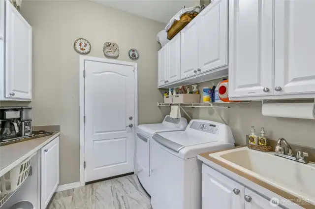 The laundry room is super functional with lots of storage, a utility sink and handy counter.