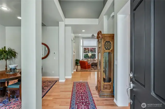 Enter on to warm hardwood floors and take in the soaring ceilings that add a sense of spaciousness to the home. The dining room is to the left, as is the office and guest suite. Ahead to the left is the primary suite and then the great room beyond.