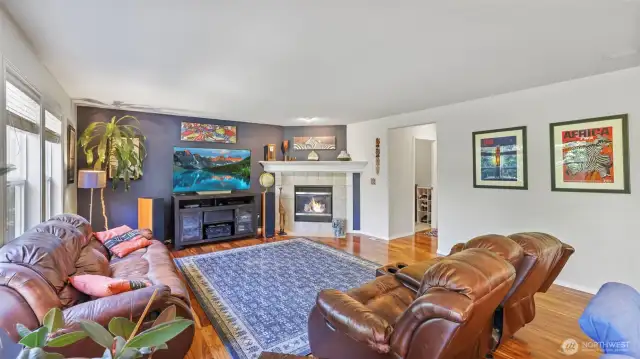 Warm hardwood flooring and a charming gas fireplace make this living room feel instantly inviting. Tucked nearby are the garage entrance and laundry area — complete with included washer and dryer for added convenience