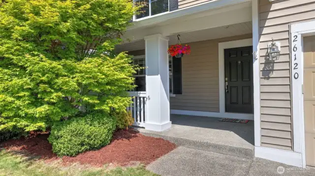 Front stairs lead up to a cozy covered porch, offering just enough space for a couple of chairs—an ideal spot to enjoy your morning coffee