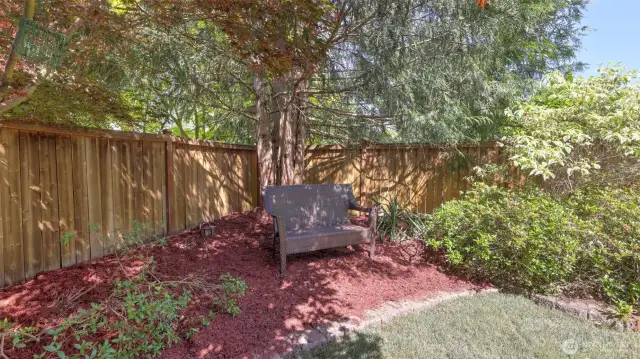 Tucked away in the back corner, a private space surrounded by lush trees and shrubs — perfect for a shed, garden seating, or your own quiet escape