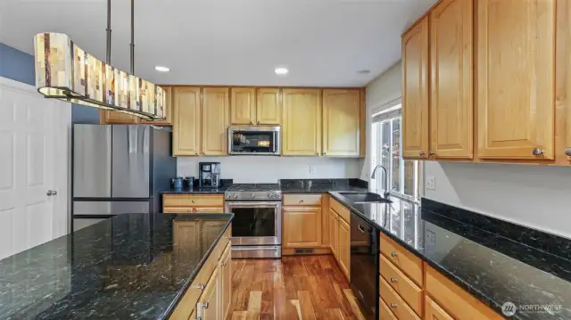 Sleek modern kitchen featuring granite countertops, premium stainless steel appliances — all included — plus a spacious walk-in pantry for added storage and convenience