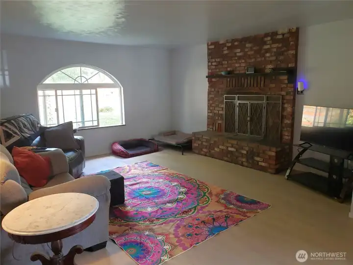 Living room with wood burning brick fireplace.