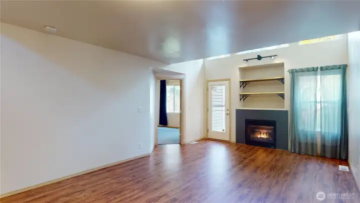 Looking from the dining room area to the back door to the entertainment patio and fully fenced back yard and the door to the mainfloor primary suite.