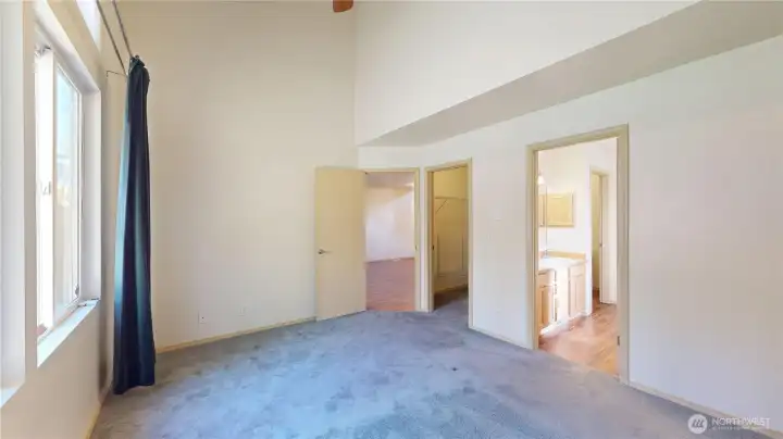Looking from the corner of the room towards the Livingroom and catching the entry to the very large walk in closet and master suite ensuite bath.