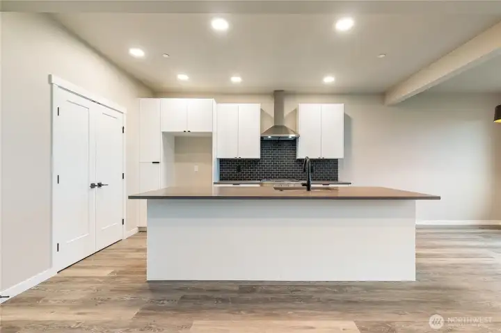 Large island with bar seating & pantry to left