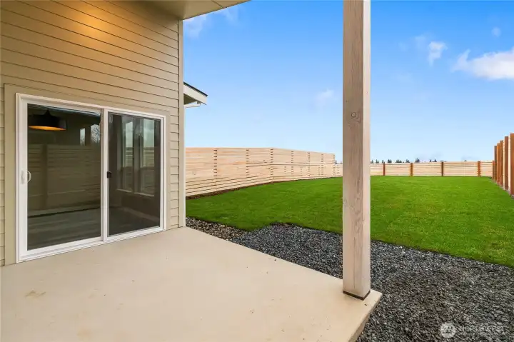 Covered patio with view of spacious grassy backyard!