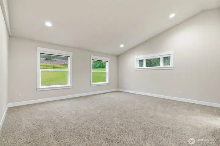 Primary bedroom featuring vaulted ceilings throughout, large walk-in closet, and 5 piece bathroom.