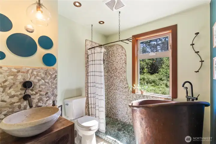 Spa like bath with river rock shower with copper tub