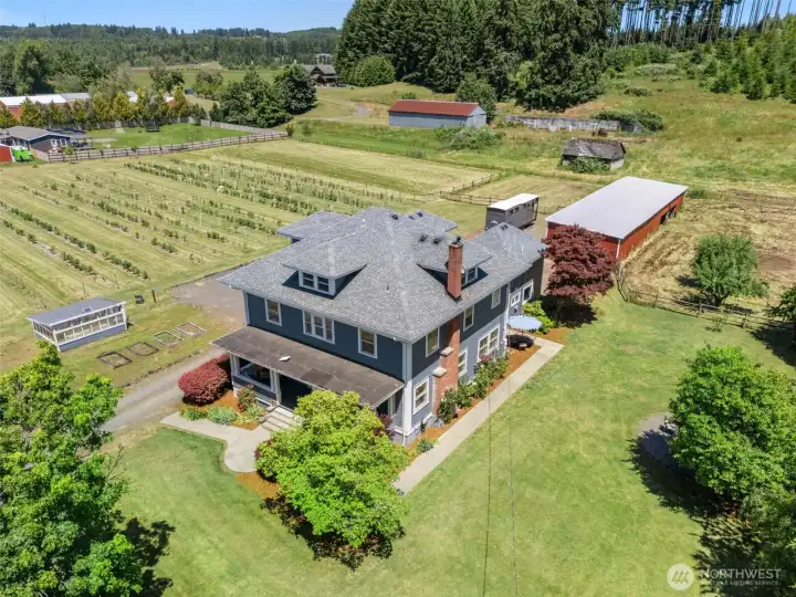 From above, the property's story unfolds—showcasing the historic home, established blueberry field, and fenced pasture that have been thoughtfully cared for and enjoyed for generations. One unique feature of the property, the established blueberry field offers eight varieties of blueberries.