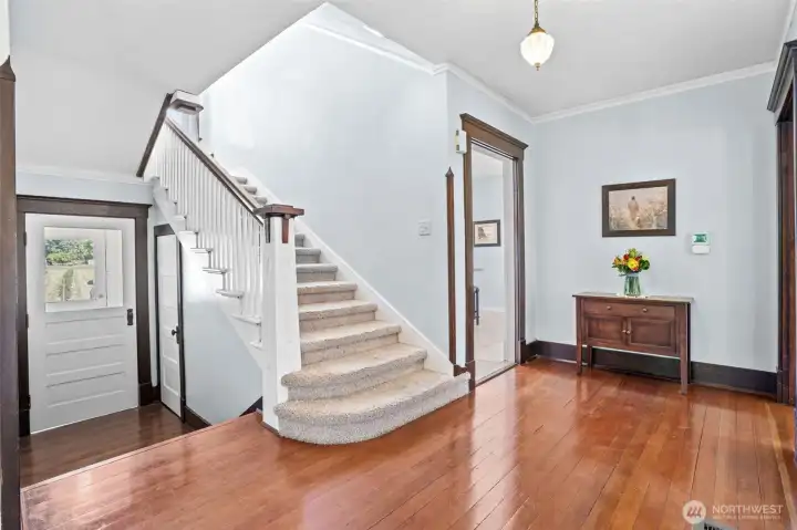 Original Craftsman woodwork takes center stage in the grand hallway, offering a glimpse into the quality and pride of construction found throughout the home.