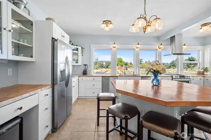 A wall of windows fills the kitchen with natural light while offering beautiful views of the surrounding acreage and established blueberry field, creating a connection between the home and the land it has overlooked for generations.