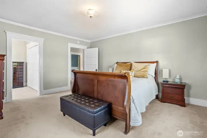 The spacious primary bedroom where a pass-through dressing room leads to the attached bath, offering ample storage and functionality while maintaining the homes character.