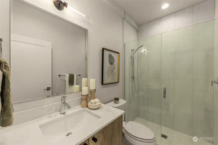 Photos of model home with similar finishes & floor plan. A glass-enclosed shower, modern vanity, and stylish finishes make this bathroom feel like your own private retreat.