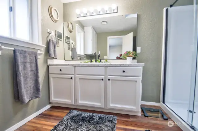 Light and bright primary bathroom with view of the lake.