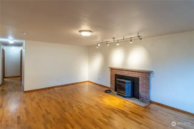 Living room with hardwood floors and pellet fireplace.