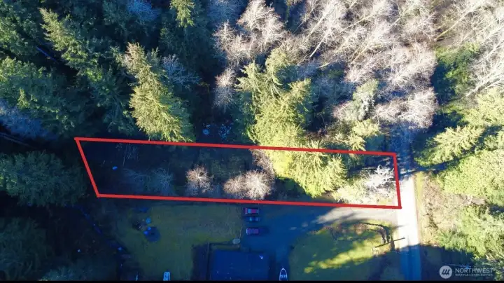 Aerial views showcase the property’s unique setting with a blend of mature evergreens, natural privacy, and selectively cleared areas ready for future possibilities ??? The lot features a gentle slope and stretches back into a peaceful wooded setting, creating a secluded retreat feel while still offering convenient paved road access. Existing improvements include a private well, approved septic design with active permit, and power at the street — helping reduce upfront development time and expense. Located near beautiful Lake Cavanaugh, this property offers the perfect opportunity to create a custom cabin, vacation getaway, or full-time mountain retreat surrounded by nature.