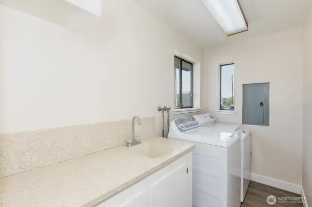 The full size laundry room is light and bright with 2 windows. There is lots of counter space and a sink.