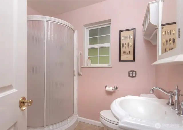 Bathroom with a walk in shower on the main level next to office space.