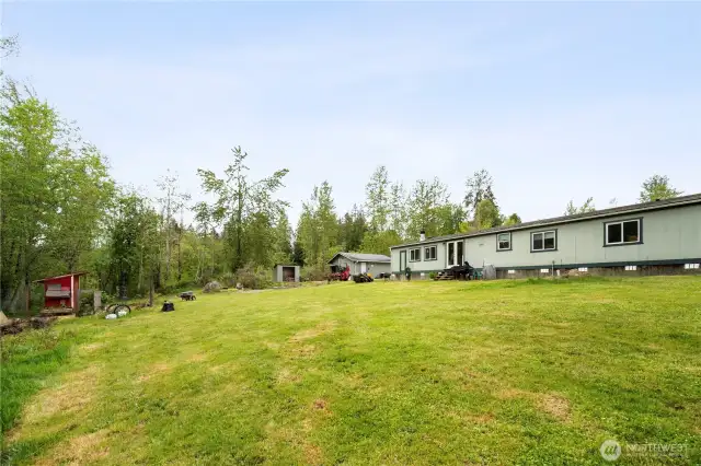 Chicken coop is to the left. Firepit and landscaped goldfish pond are ahead.