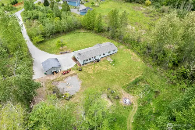 Breathtaking aerial view showcasing over 1,800 sq. ft. of serene living space nestled on 6.5 private acres to explore.