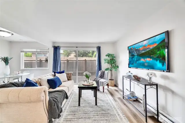The bright and airy living room opens to a generous, fully fenced patio for outdoor living.