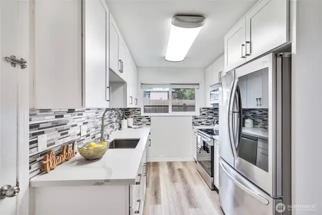 The kitchen was fully remodeled in 2020, with quartz countertops, trendy backsplash, shaker cabinets and all new appliances.