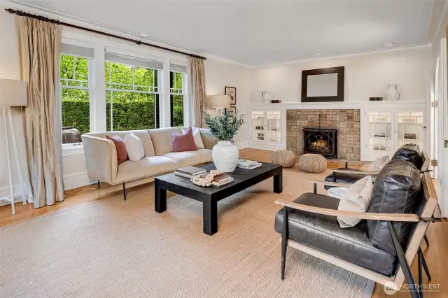 Two sets of beautiful arched glass French doors lead into the spacious living room, which is anchored by a spectacular Batchelder fireplace with lighted built-ins on either side.