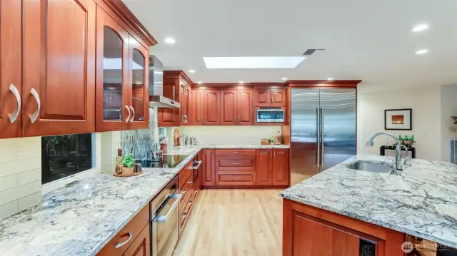 The kitchen is magnificent in every way.  All appliances are top of the line high end brands.  Granite counters and island with a vegetable sink and tile backsplash.  Custom cabinets with several with glass backs to see through to the outside.  Large drawers for pans a drawer for garbage and recycling.
