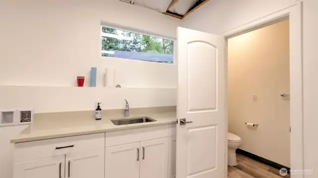 A view of the kitchenette space and half bath.