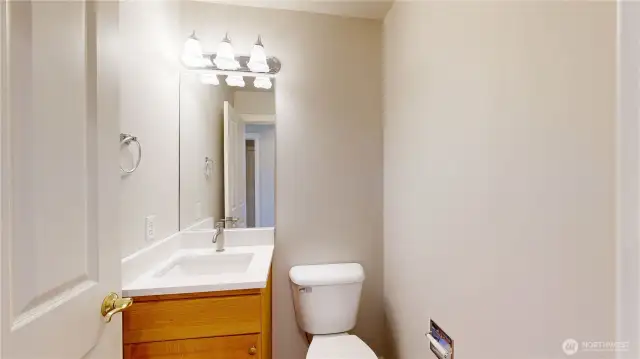 Clean and functional powder room featuring a single-sink vanity with updated quartz countertop, sleek faucet, and a large framed mirror.
