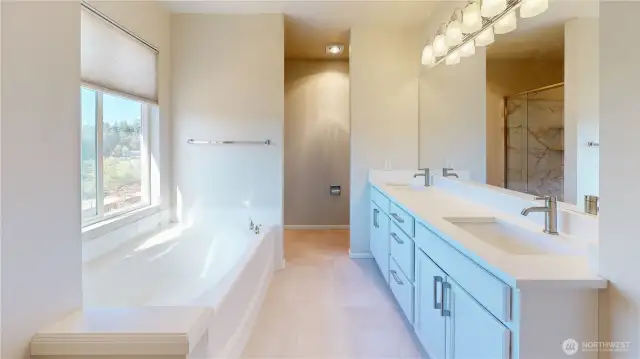 Remodeled ensuite bath, featuring a spacious dual-sink vanity with quartz countertops and modern fixtures. Natural light pours in through the large window above the soaking tub, creating a serene spa-like atmosphere.
