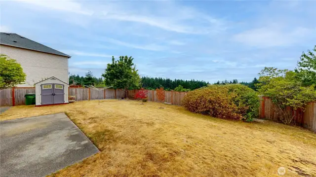 Fully fenced backyard offering privacy and peaceful views with no neighbors behind. Spacious yard features a storage shed, mature landscaping, and room to garden, play, or entertain. Concrete patio provides the perfect spot for outdoor dining or relaxing while enjoying the natural surroundings.
