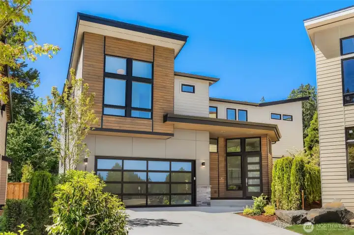 Tucked back on lot 4, Extensive use of stained cedar siding, contemporary garage door, and professionally designed landscaping create exceptional curb appeal