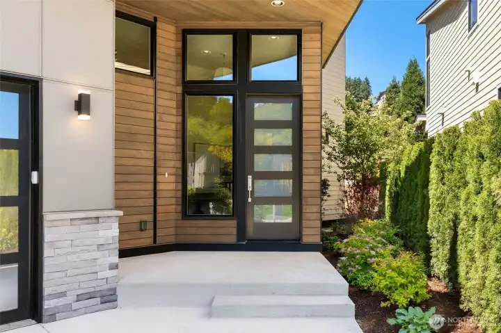 Sprawling covered entry highlighted by stained cedar and cultured stone details with cedar ceiling detail to welcome all