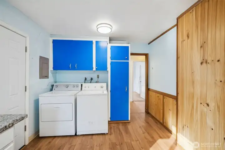 Washer and dryer conveniently located includes cabinets for supply storage.