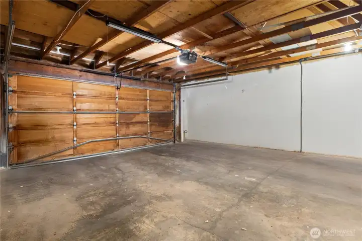 Full two-car garage featuring EV plug-in and overhead pull-down storage access