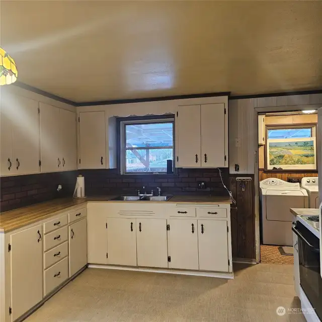 This country kitchen is large enough for a table and chairs. The cabinets are a light color keeping this room bright!