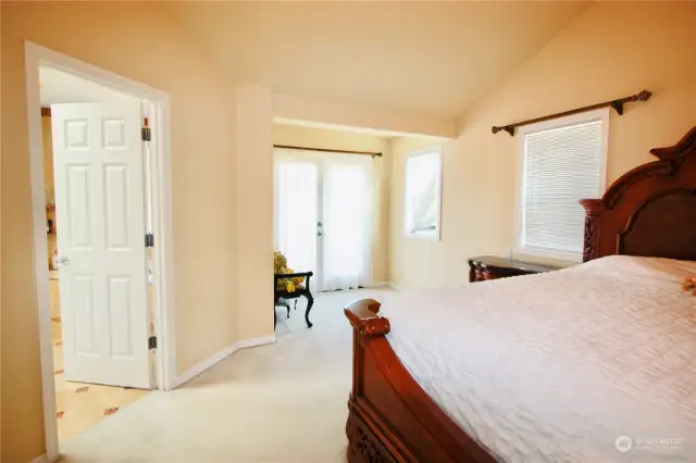 Primary bedroom showcasing balcony that overlooks the backyard.