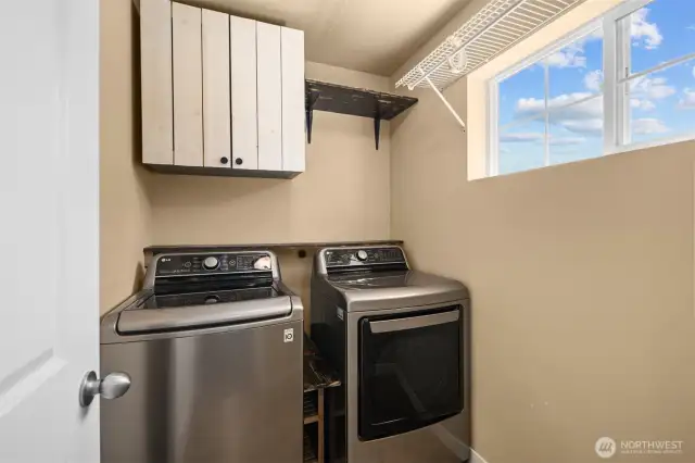 Upstairs laundry is conveniently located near all bedrooms and features extra built-in cabinetry for added storage and ease.