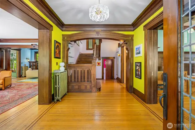 Step into a bright foyer featuring a classic oak staircase, with the living room to the left and formal dining room to the right.