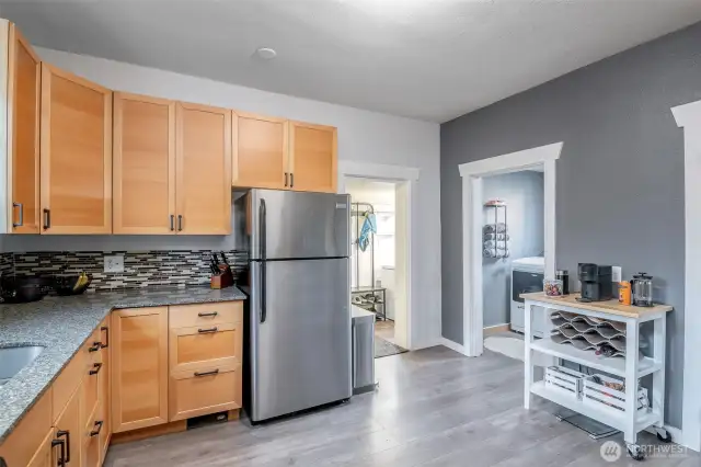 The kitchen has easy access to the back mud room and out to the backyard for a bar b que.